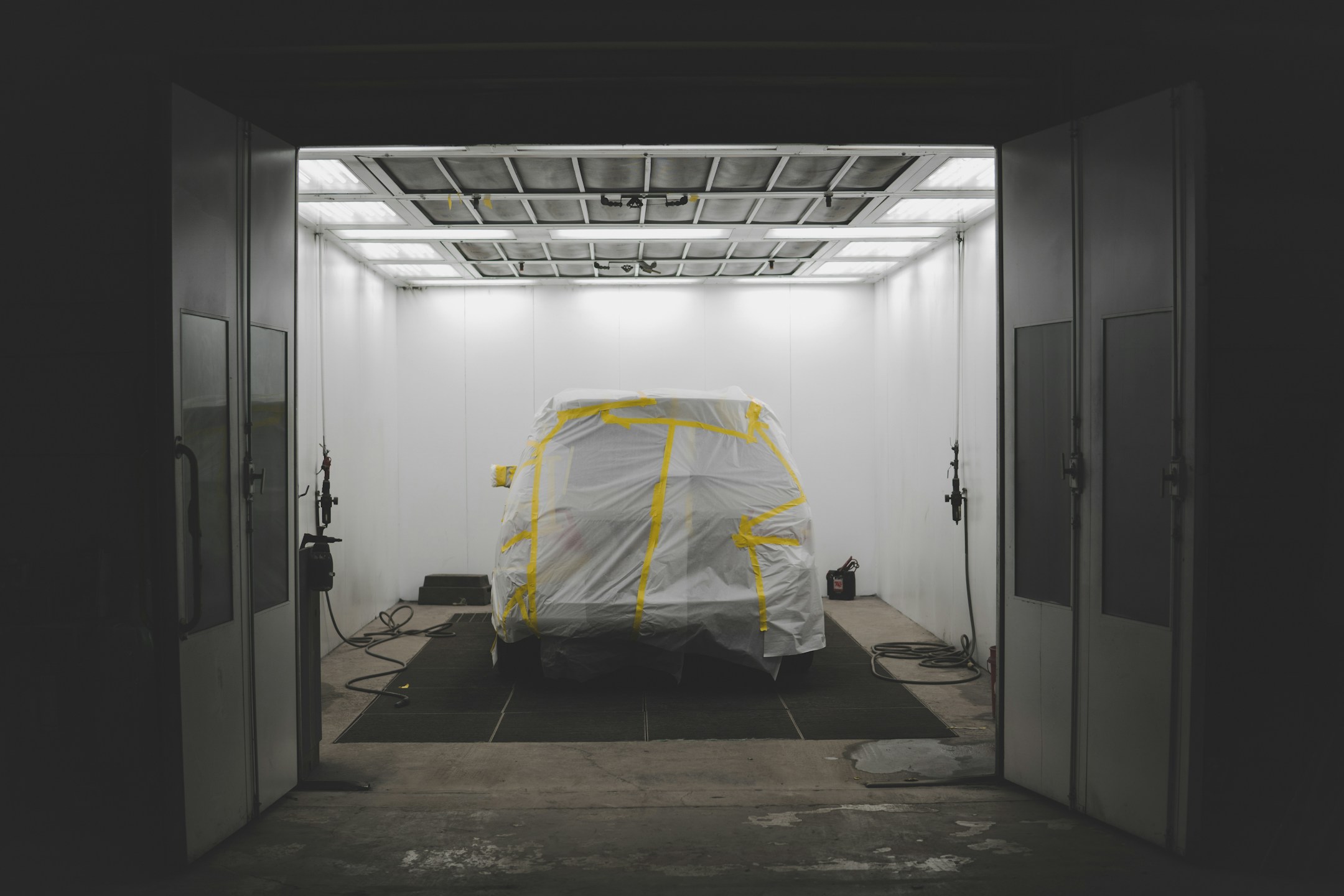 Car covered for painting inside a paint booth